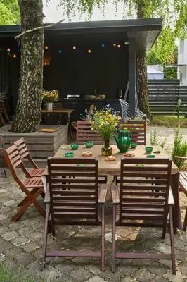 a wooden table with chairs and a vase of flowers at 
