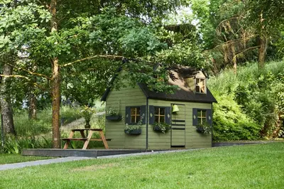 a small green house in the middle of a yard at 