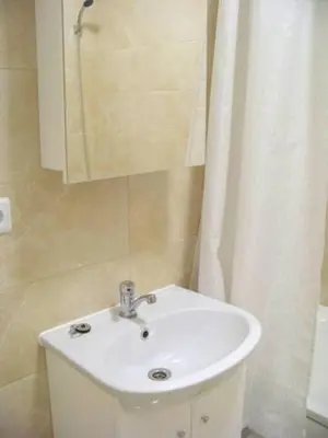 a bathroom with a white sink and a mirror at Near PANORAMA apartment Self check-in Garage free in Vilnius