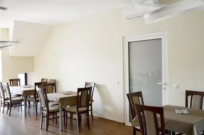 a dining room with tables and chairs and a door at Tip Tap Guest House in Druskininkai