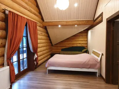 a bedroom with a bed in a log cabin at Poilsio ir sveikatinimo sodyba Pušų Šlamesy in Vilnius