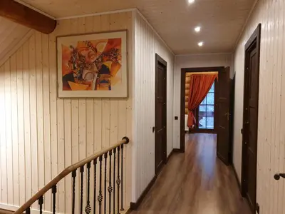 a hallway of a home with a staircase and a painting on the wall at Poilsio ir sveikatinimo sodyba Pušų Šlamesy in Vilnius