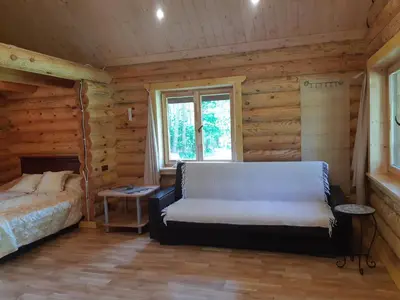 a bedroom with a bed in a log cabin at Pušų Šlamesy in Vilnius