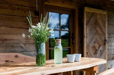 a wooden table with a vase and cups on it at ETNO house in Ricieliai