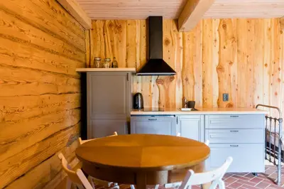 a wooden kitchen with a table and a stove at ETNO house in Ricieliai
