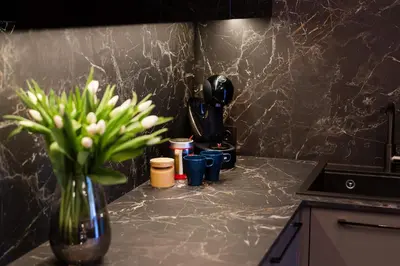 a vase with flowers in it on a kitchen counter at Stay in Kaunas & Park House in Kaunas