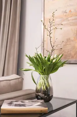 a glass vase with a plant on a table at Stay in Kaunas & Park House in Kaunas