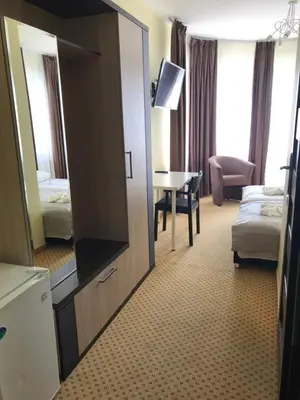 a hotel room with a large mirror and a bedroom at La-Vanda in Šiauliai