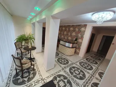 a lobby with a table and chairs and a chandelier at La-Vanda in Šiauliai