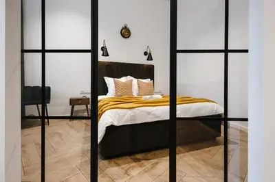 a bedroom with a bed with glass walls at Modern apartment in Kaunas city center in Kaunas