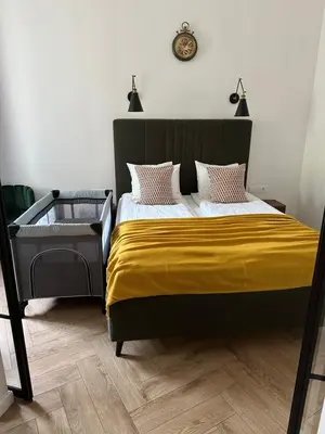 a bedroom with a large bed with a yellow blanket at Modern apartment in Kaunas city center in Kaunas