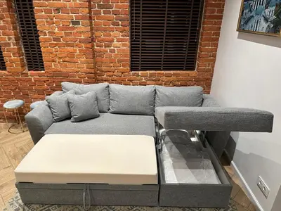 a couch in a living room with a brick wall at Modern apartment in Kaunas city center in Kaunas