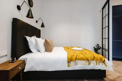 a bedroom with a bed with a yellow blanket on it at Modern apartment in Kaunas city center in Kaunas