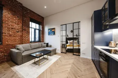 a living room with a couch and a brick wall at Modern apartment in Kaunas city center in Kaunas
