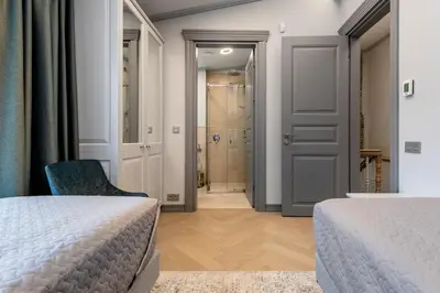 a bedroom with two beds and a chair and a corridor at #stayhere - Modern Luxury Apartments in the Heart of Old Town Vilnius in Vilnius