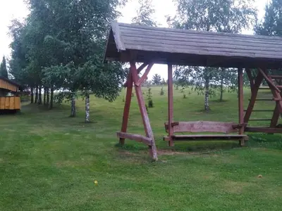 a park with a wooden gazebo in a field at Kaimo turizmo sodyba Stromelė in Baltriškės