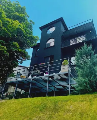 a black building with a balcony on a hill at Very Bad Hootel in Kaunas