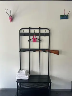 a black iron shelf against a white wall at Very Bad Hootel in Kaunas
