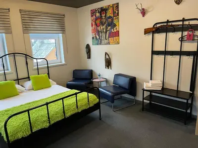 a bedroom with a bed and two chairs in it at Very Bad Hootel in Kaunas
