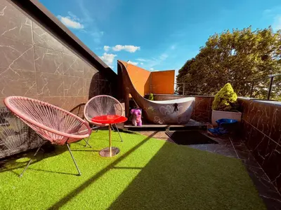 a patio with two chairs and a tub on the grass at Very Bad Hootel in Kaunas