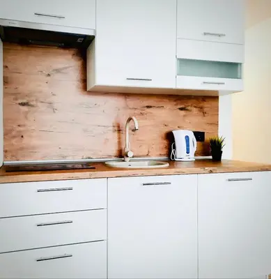 a kitchen with white cabinets and a sink at M&M Apartment VII Self CHECK-IN in Panevėžys