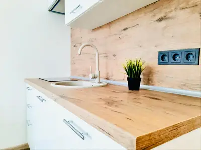 a kitchen with a wooden counter top and a sink at M&M Apartment VII Self CHECK-IN in Panevėžys