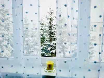 a candle in front of a window with a christmas tree at M&M Apartment VII Self CHECK-IN in Panevėžys