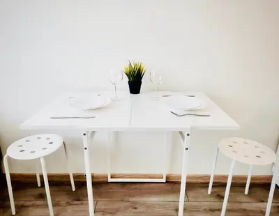 a white table with two white chairs and a white table with glasses at M&M Apartment VII Self CHECK-IN in Panevėžys