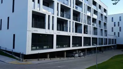 a large white building with a lot of windows at Ozas Green Apartment in Vilnius