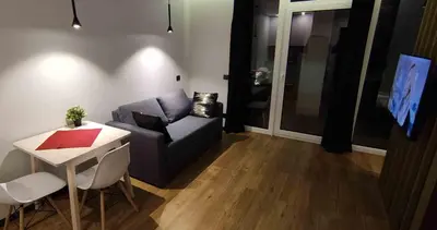 a living room with a couch and a table at Ozas Green Apartment in Vilnius