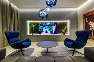 a living room with two blue chairs and a tv at Luxury Smart Home Apartment in Vilnius Old Town, Sleep on Hästens in Vilnius