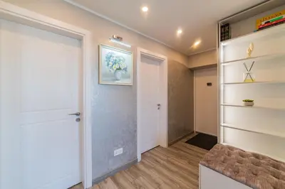 a hallway with a white door and shelves at E.D. Luxury Apartaments in Šiauliai