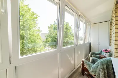 a room with windows and a chair with a view at E.D. Luxury Apartaments in Šiauliai