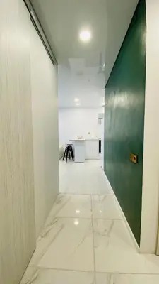 an empty hallway with white walls and a green wall at Green & White Apartament in Anykščiai