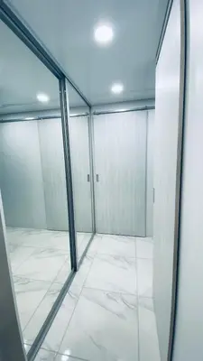 a room with glass doors and a white tile floor at Green & White Apartament in Anykščiai