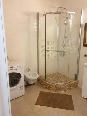 a bathroom with a shower and a washing machine at Skuodo 2E in Kaunas