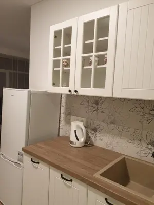 a kitchen with white cabinets and a white refrigerator at Skuodo 2E in Kaunas