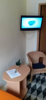a room with a table and a tv on a wall at Small room with a private external bathroom in Kaunas