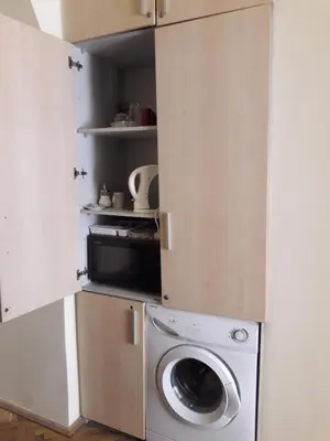 a kitchen with a washing machine and a microwave at Small room with a private external bathroom in Kaunas
