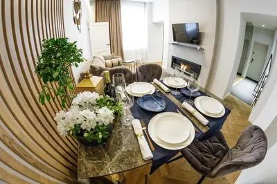 a dining room table with white plates and flowers on it at Old Town apartment l Self check in in Vilnius