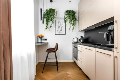 a kitchen with white cabinets and a stool in it at Old Town apartment l Self check in in Vilnius