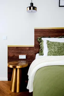a bedroom with a bed with a gold table next to it at Old Town apartment l Self check in in Vilnius