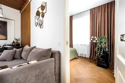 a living room with a couch and a living room with a window at Old Town apartment l Self check in in Vilnius