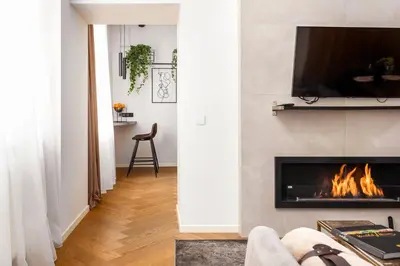 a living room with a fireplace and a tv at Old Town apartment l Self check in in Vilnius