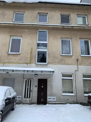 a building with snow in front of it at Comfortable Stay in Siauliai in Šiauliai