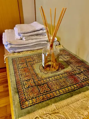 a vase with sticks in it sitting on a rug at Comfortable Stay in Siauliai in Šiauliai
