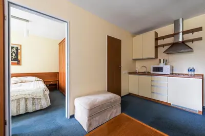 a room with a bed and a kitchen with a microwave at ORO Dubingiai in Giraičiai