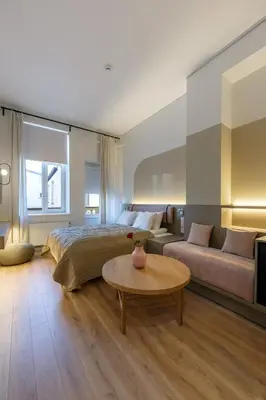a bedroom with a bed and a couch and a table at Laisves ave. Apartments Mini in Kaunas