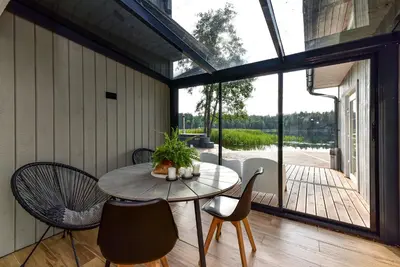 a screened in porch with a table and chairs at Namelis ant vandens 
