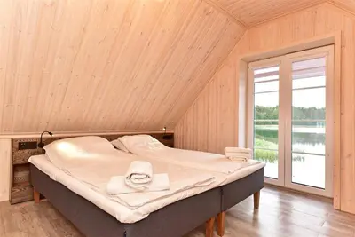 a large bed in a room with a large window at Namelis ant vandens 